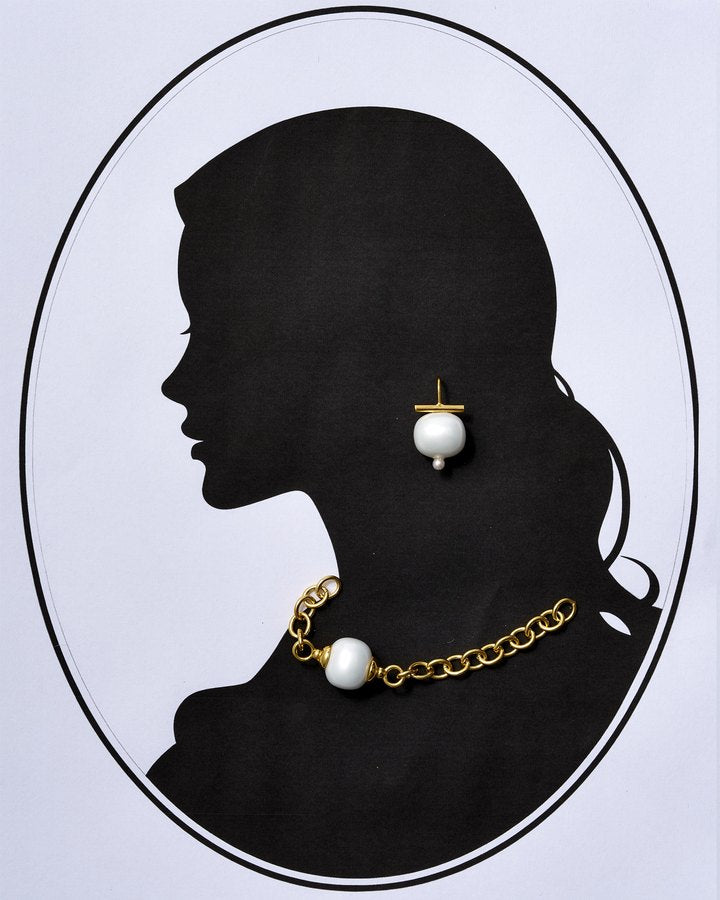 Cameo silhouette wearing a white Pebble Pearl earring and gold chain with pearl